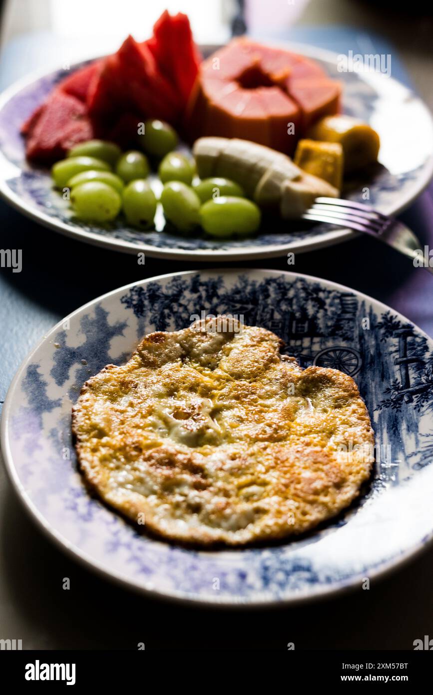 Nourriture du matin avec oeuf papaye frite raisin de pastèque et bananes dans une assiette. Alimentation saine. Fruits et protéines. Banque D'Images