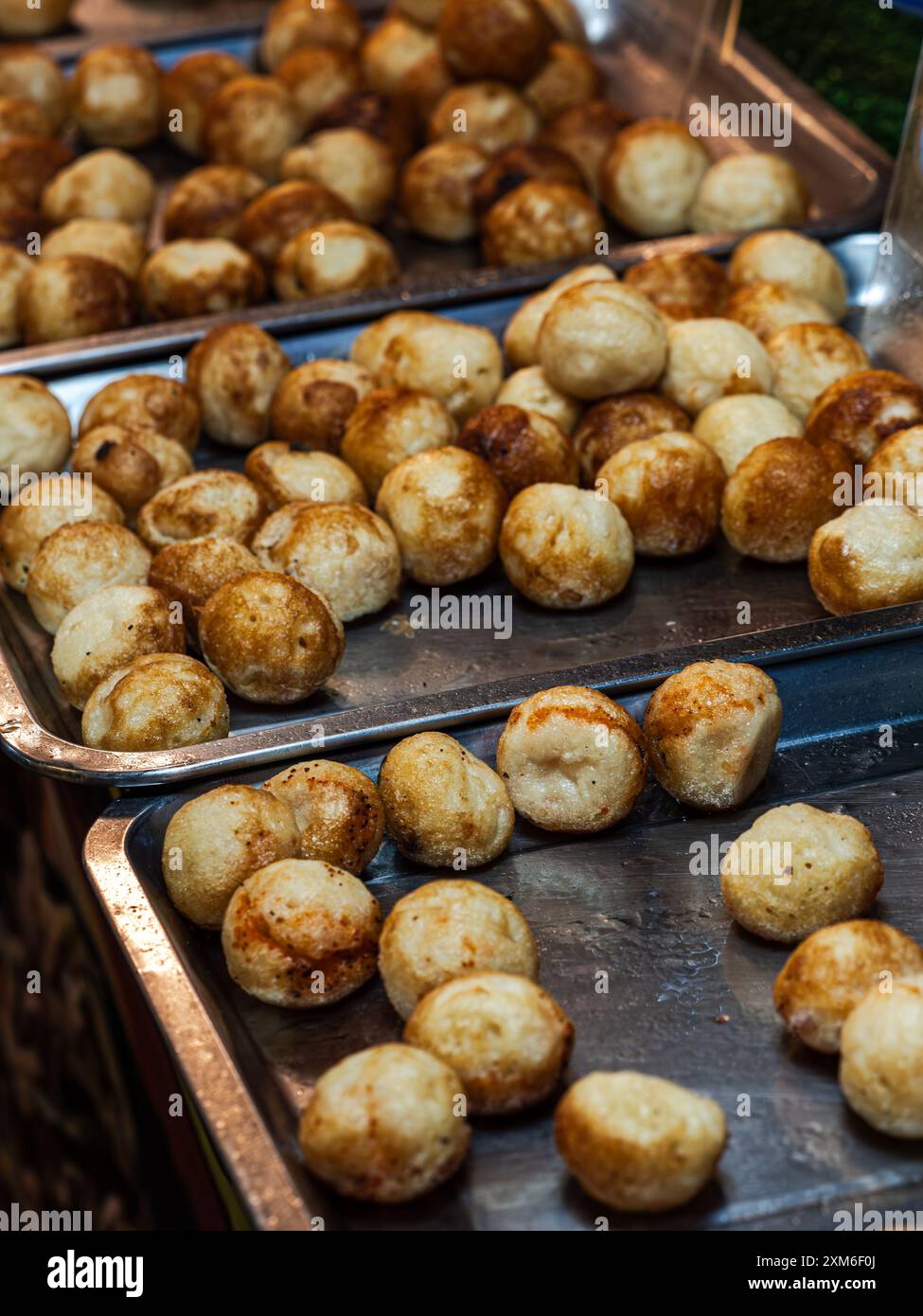 Gros plan de plateaux remplis de boules de frites brunes dorées Banque D'Images