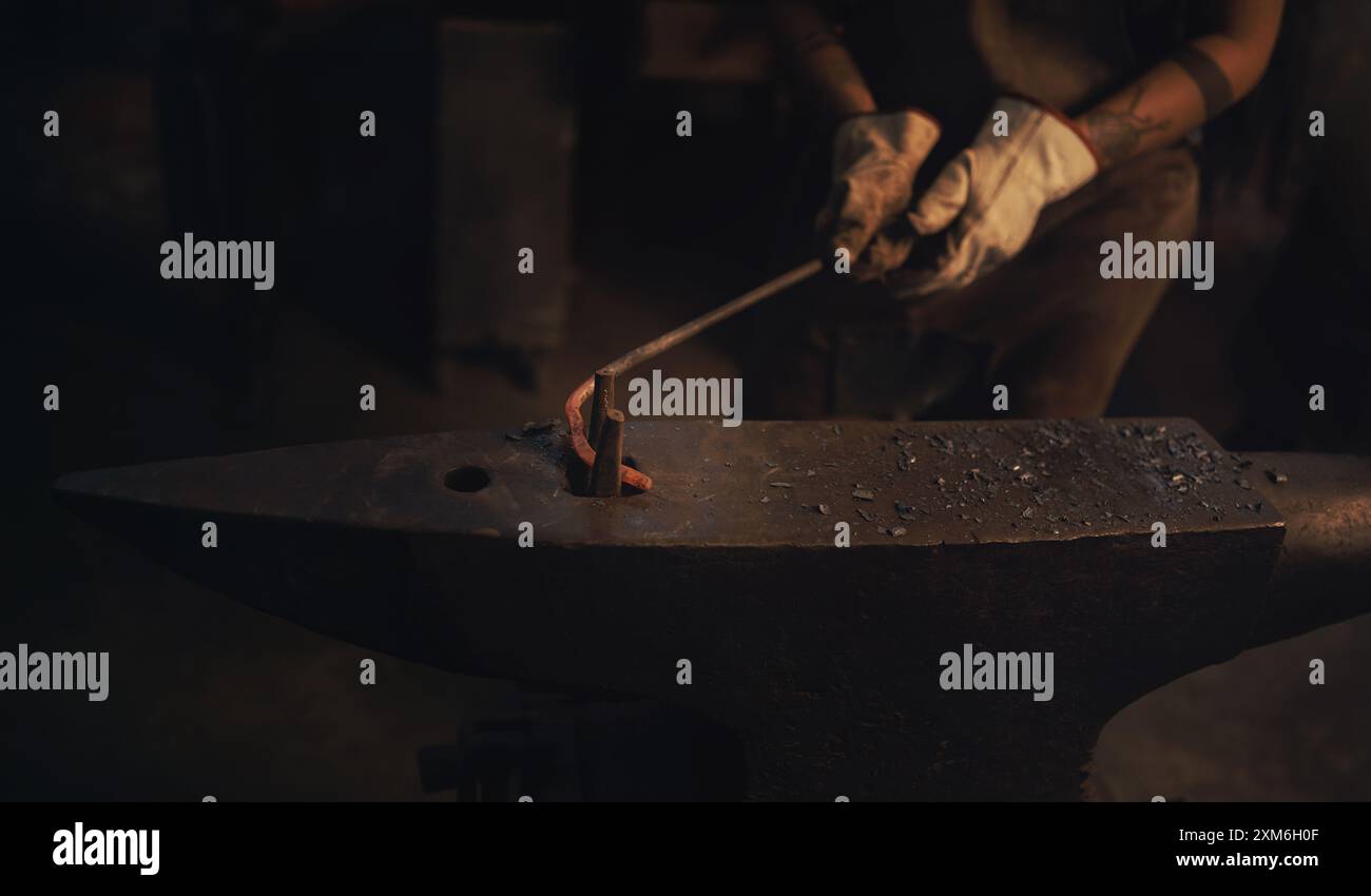 Forge, mains et chaleur avec forgeron dans l'atelier de métal pour la fabrication industrielle ou la production. Feu, fonderie et outil avec artisan professionnel Banque D'Images