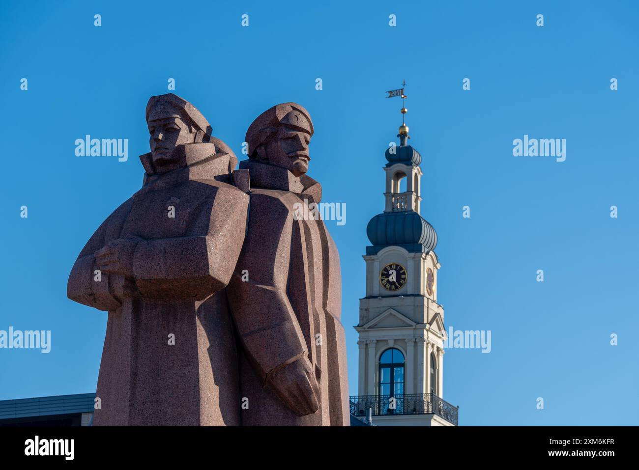 Monument des tirailleurs lettons, se dresse devant le Musée de l'occupation, derrière lui la tour de l'Hôtel de ville, Riga, Lettonie Banque D'Images