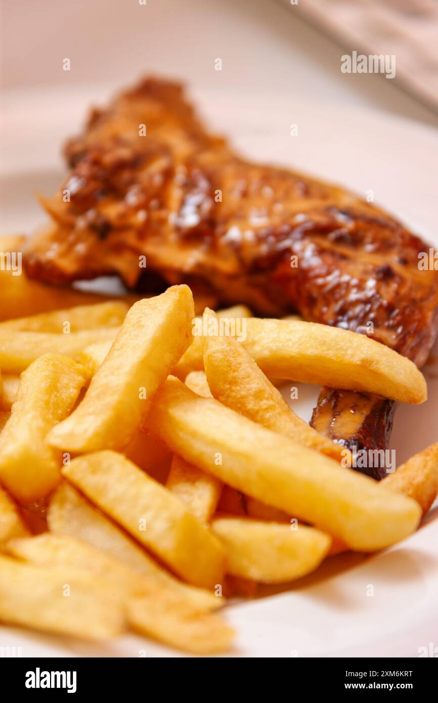 chips frites et cuisse de poulet dans une assiette Banque D'Images