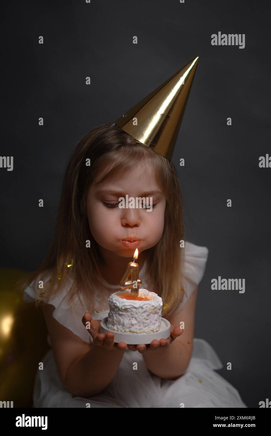 Une petite fille avec un gâteau d'anniversaire. vertical Banque D'Images