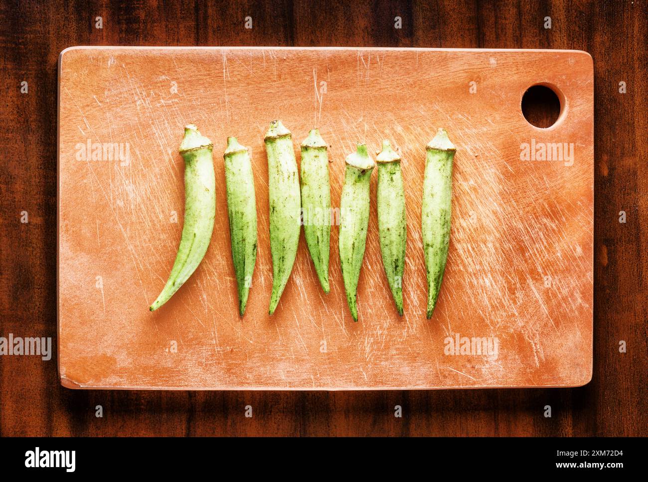 Gousses de graines vertes fraîches okra sur une planche de bois. Des aliments écologiques sains Banque D'Images