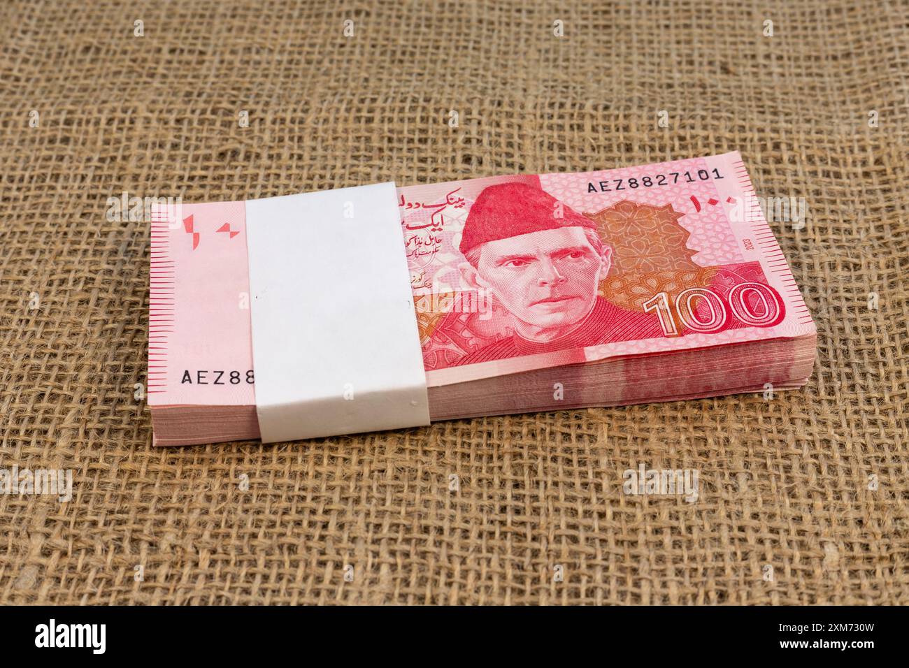 Pile de billets de 100 roupies pakistanaises sur la surface de toile de jute Banque D'Images