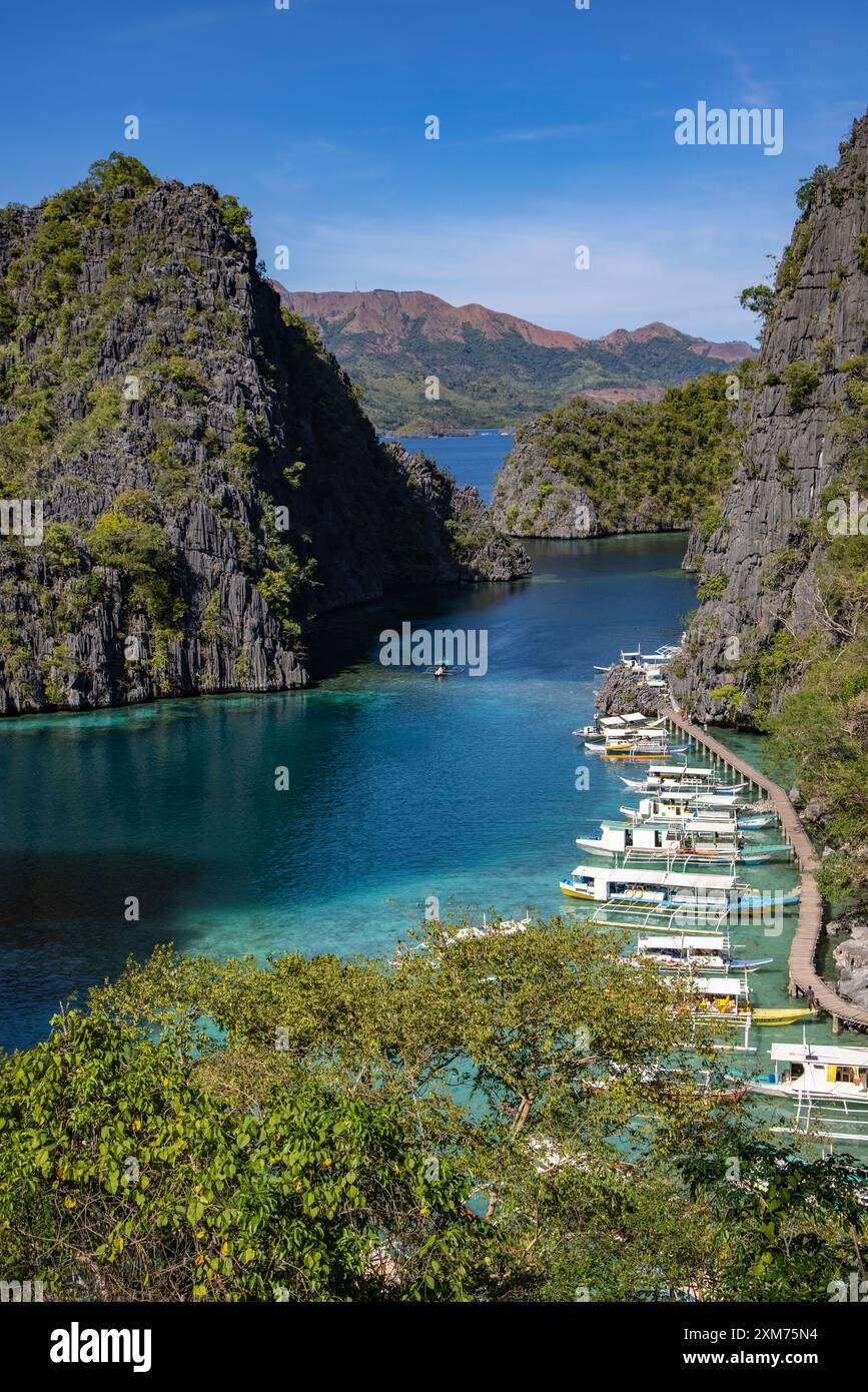 Vue des bateaux d'excursion en canoë Bangka Outrigger amarrés dans la lagune, vue depuis le pont d'observation en route vers le lac Kayangan, Coron, Palawan, Philippines Banque D'Images