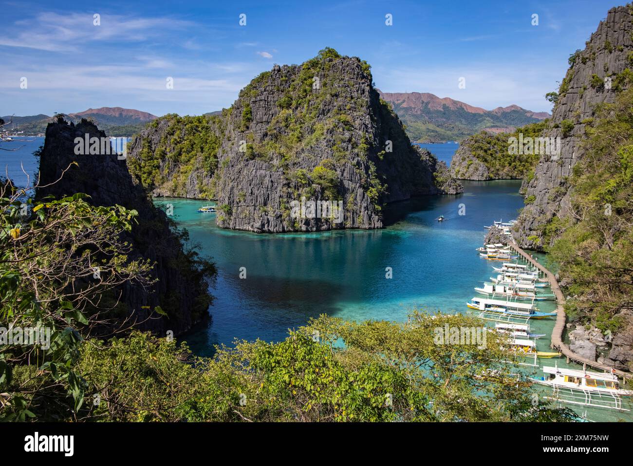 Vue des bateaux d'excursion en canoë Bangka Outrigger amarrés dans la lagune, vue depuis le pont d'observation en route vers le lac Kayangan, Coron, Palawan, Philippines Banque D'Images