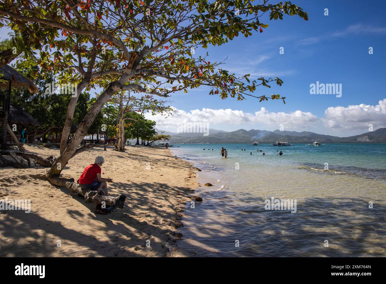 Les gens se détendent sur la plage et dans l'eau à Cowrie Island, Honda Bay, près de Puerto Princesa, Palawan, Philippines Banque D'Images