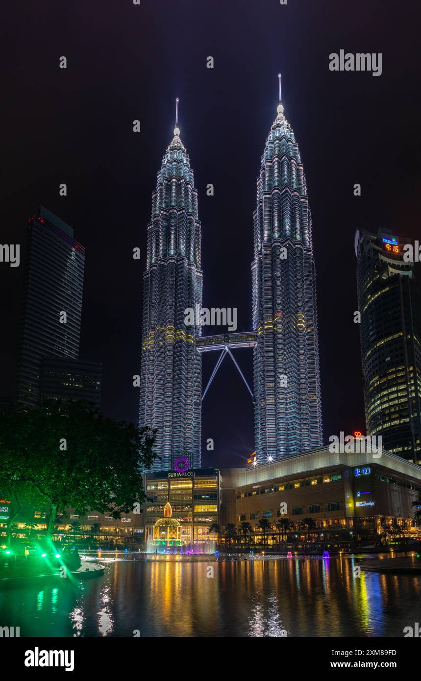 Une photo des tours jumelles Petronas, du spectacle des fontaines d'eau et de lumière du parc KLCC et du centre commercial Suria KLCC la nuit. Banque D'Images