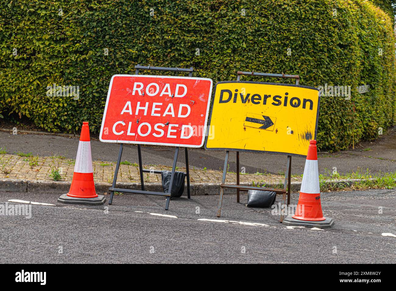 Signalisation dans le village de Marnhull, Sturminter Newton, Dorset conseillant la fermeture de la route, la déviation de la circulation et des cônes d'avertissement Banque D'Images