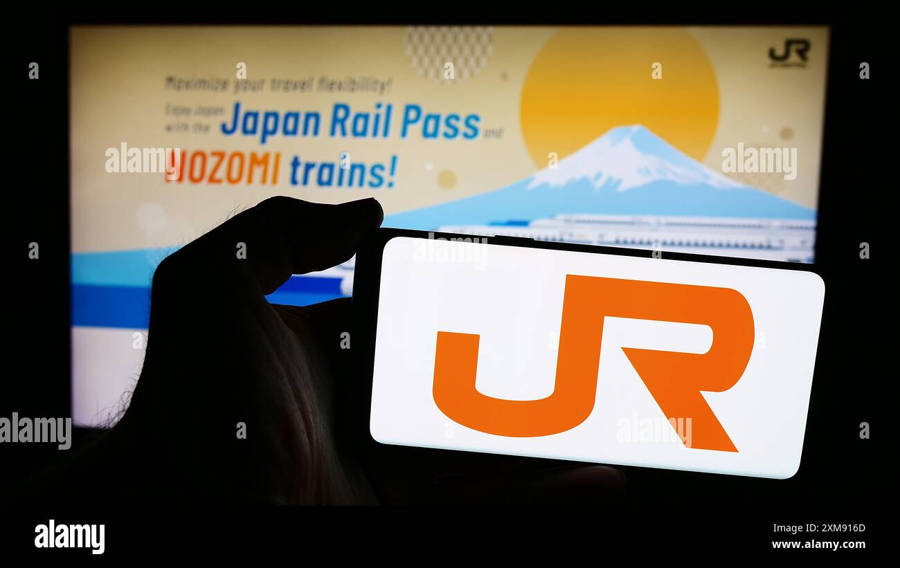 Personne tenant un smartphone avec le logo de l'entreprise ferroviaire japonaise Central Japan Railway Company en face du site Web. Concentrez-vous sur l'affichage du téléphone. Banque D'Images