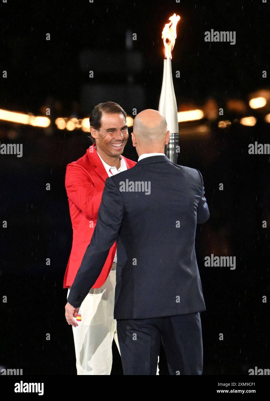 fomer-french-footballer-zinedine-zidane-r-hands-over-an-olympic-torch