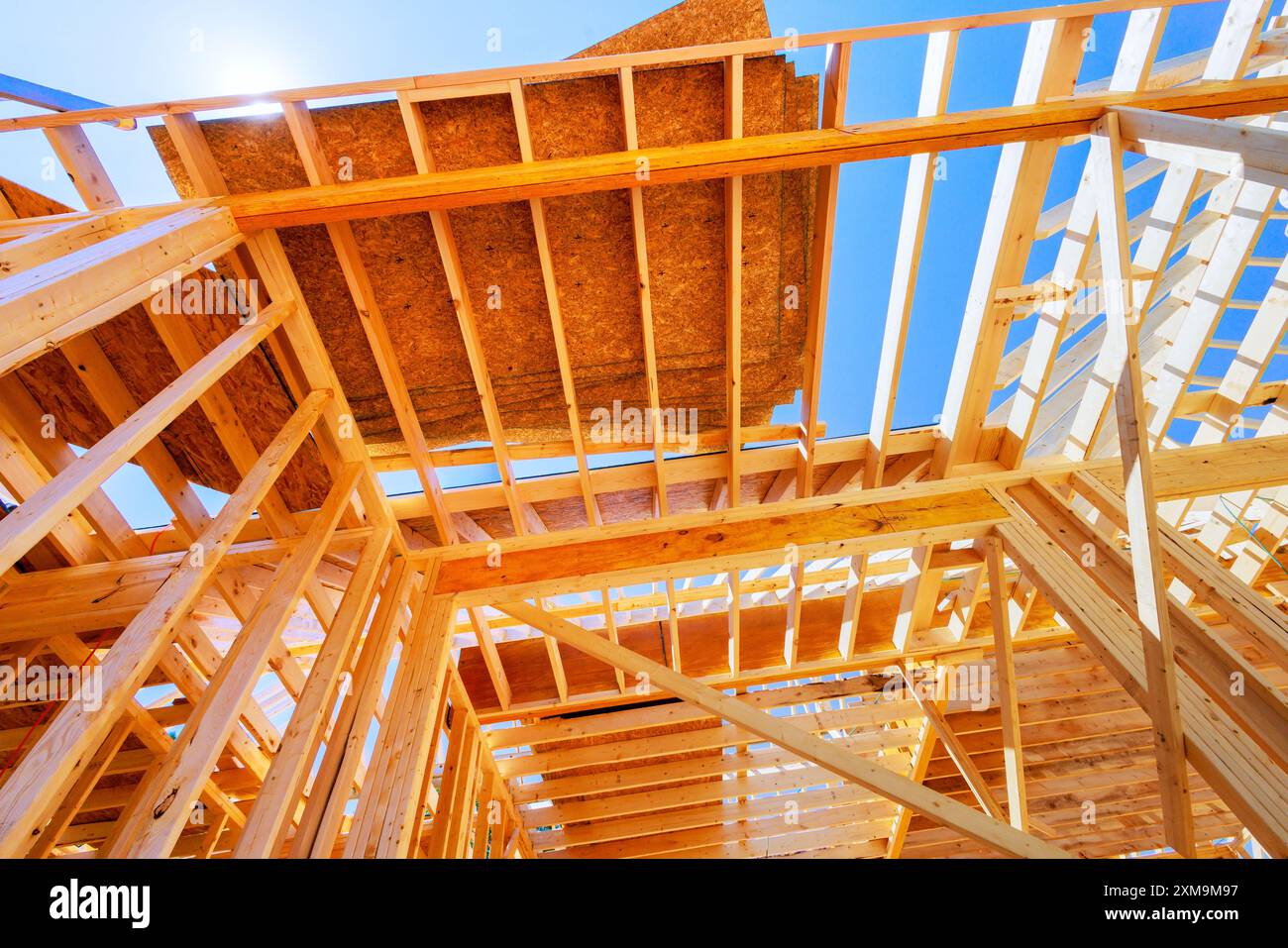 À la charpente du chantier de construction avec poutres en bois, poteaux, fermes pour la nouvelle maison Banque D'Images