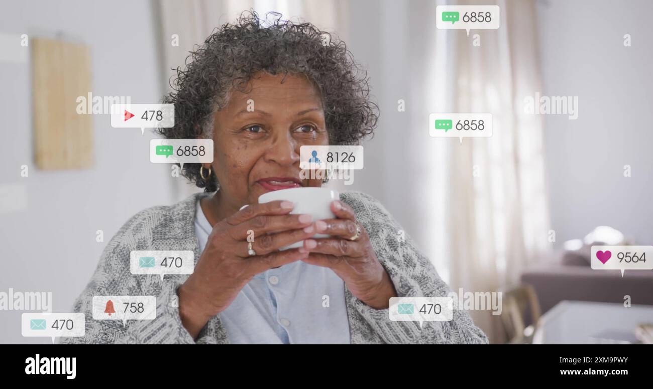 Boire du café, femme âgée entourée par l'image des notifications des médias sociaux Banque D'Images