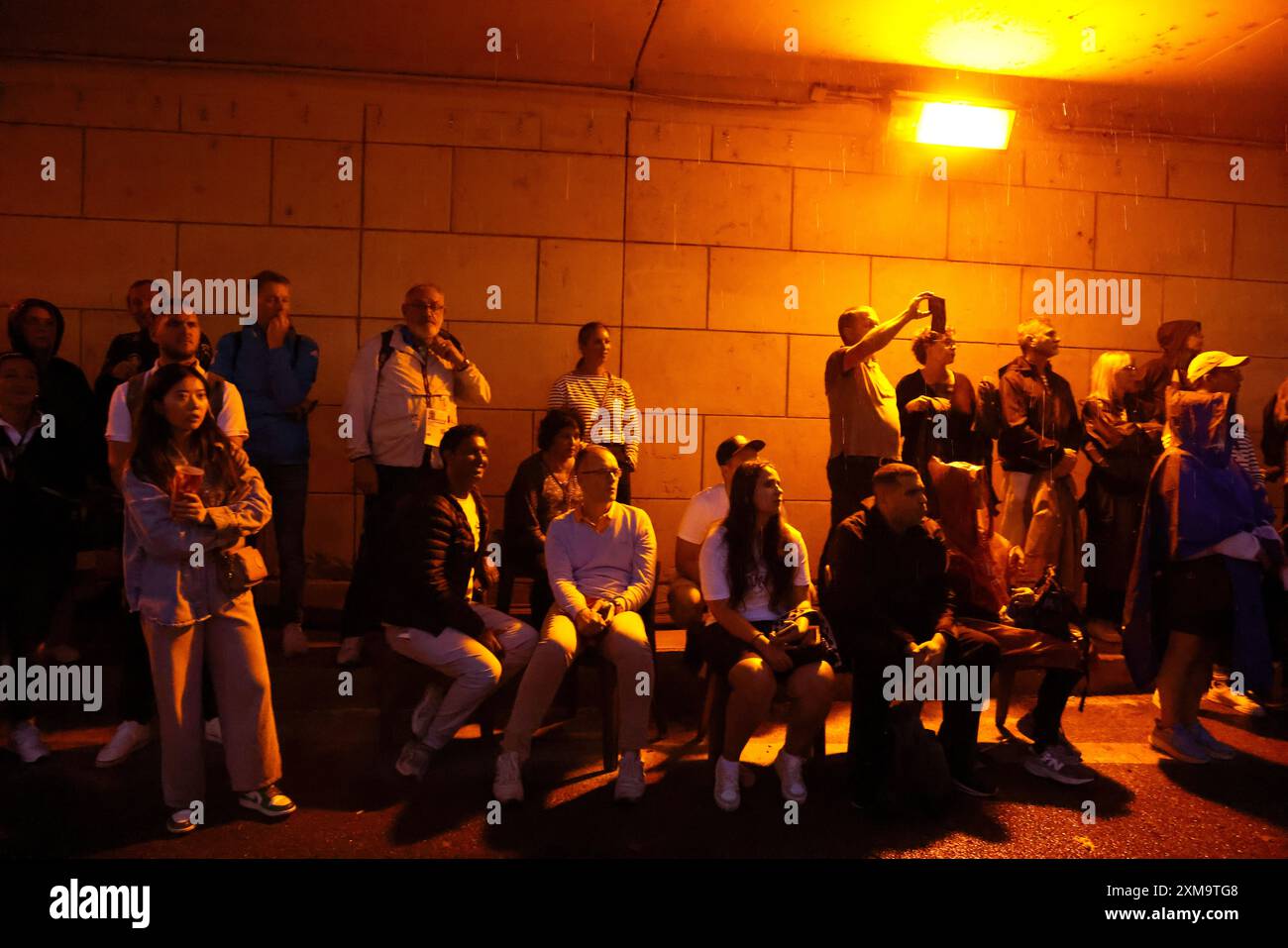 Paris, France. 26 juillet 2024. Cérémonies d'ouverture olympique. Les spectateurs se rassemblent sous le pont du Pont de Arcole pour rester à l'abri de la pluie tandis que les cérémonies d'ouverture des Jeux Olympiques de Paris de 2024 se déroulent sur des écrans de télévision géants installés le long du fleuve. Crédit : Adam Stoltman/Alamy Live News Banque D'Images