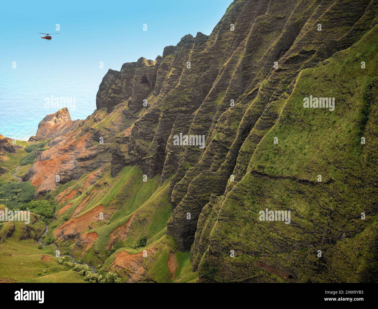 Vue aérienne depuis un hélicoptère de vol au-dessus de la côte Na Pali sur l'île hawaïenne de Kaua'i, Hawaï, États-Unis. Les falaises le long du rivage s'élèvent jusqu'à 1 200 mètres (4 000 pieds) au-dessus de l'océan Pacifique. Banque D'Images