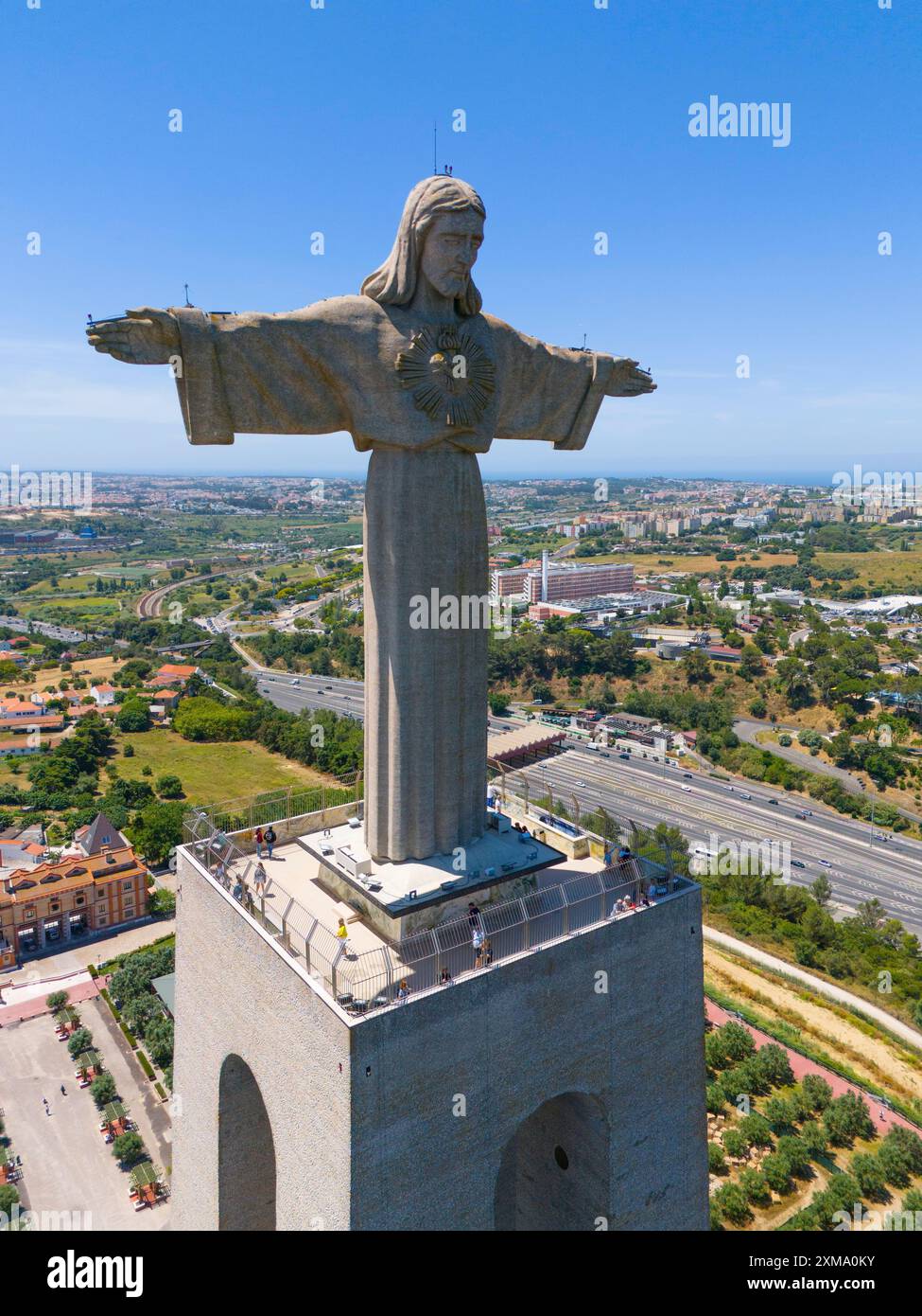 Grande statue de Jésus avec les bras tendus sur une plate-forme, surplombant le paysage urbain par une journée d'été claire, vue aérienne, Statue Cristo Rei, Almada Banque D'Images