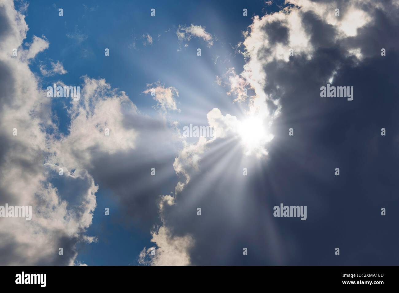 Nuages de pluie avec le soleil brille à travers, rayons de soleil, ciel bleu Banque D'Images