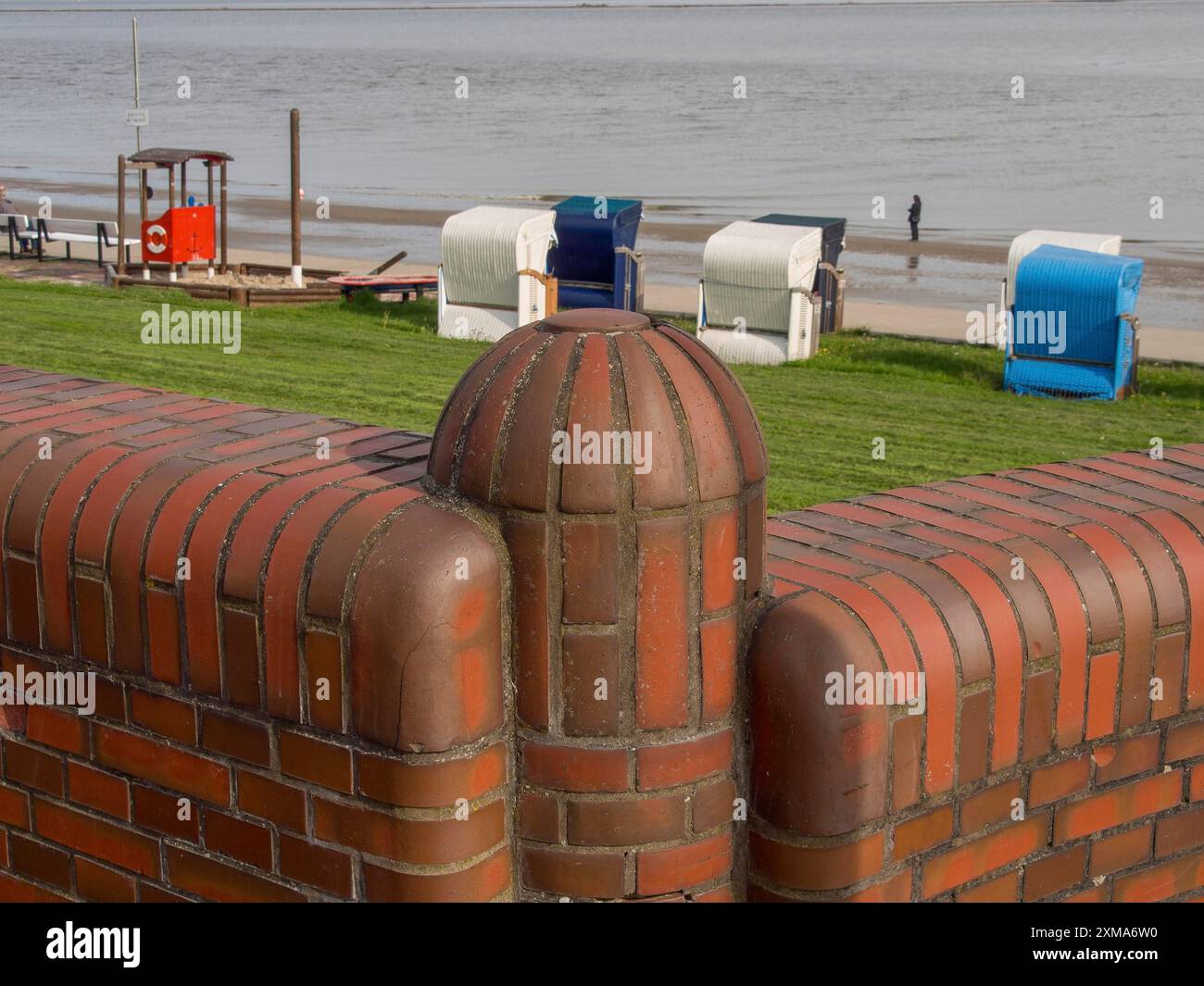 Chaises de plage et mur de briques avec vue sur la mer et une pelouse, wilhelmshaven, allemagne Banque D'Images