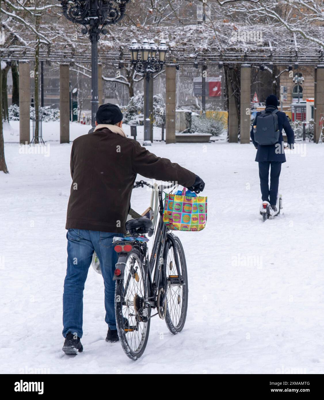 Hiver dans la ville, cycliste pousse son vélo sur la couverture de neige fermée devant l'opéra, pilote de scooter électrique, Francfort-sur-le-main, Hesse, Allemagne Banque D'Images