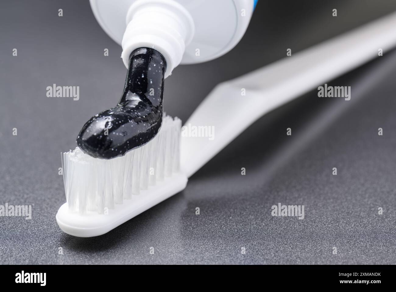 Dentifrice blanchissant au charbon noir sur brosse à dents blanche Banque D'Images