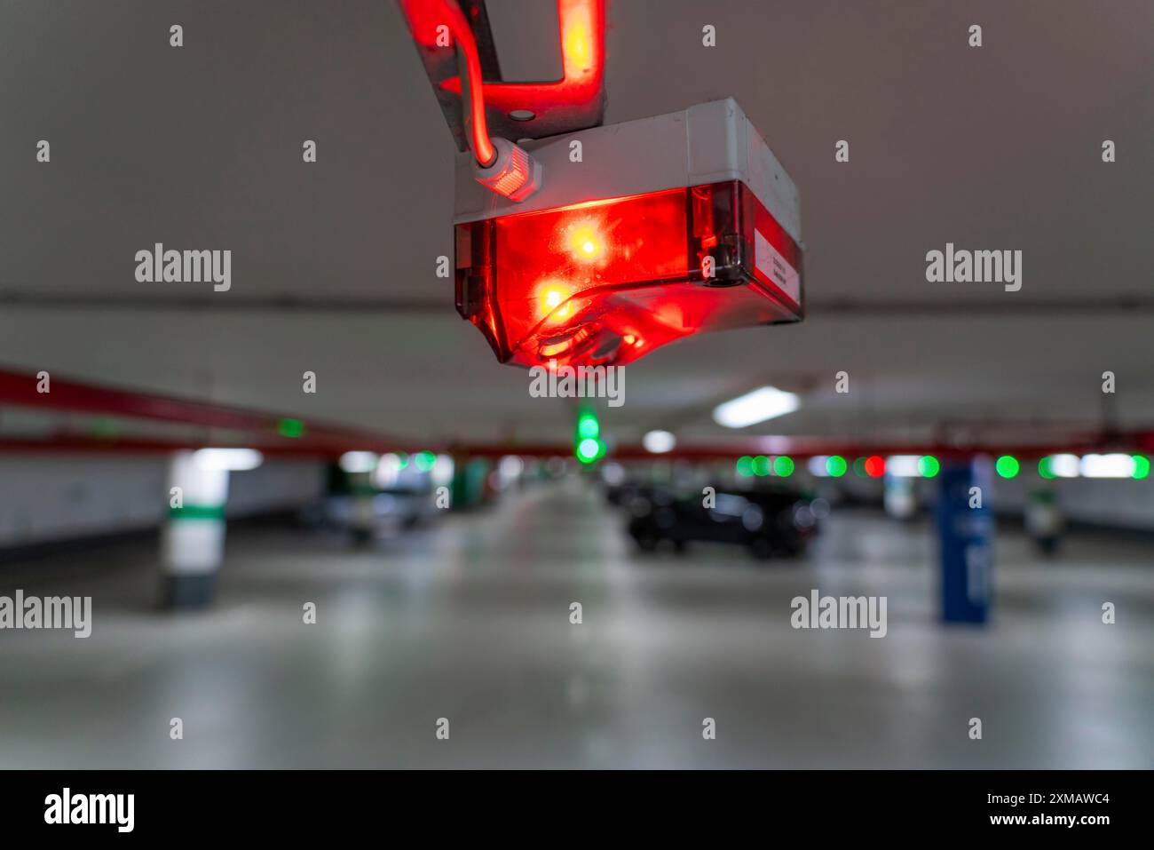 Les parkings souterrains, les parkings à plusieurs étages, les lampes rouges ou vertes au plafond indiquent aux conducteurs si une place de parking est libre ou occupée, et donc Banque D'Images