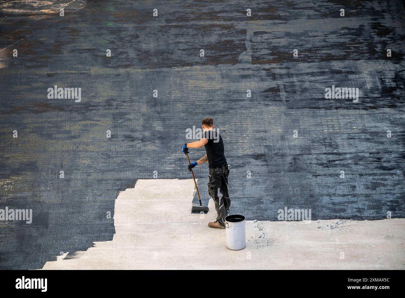 Chantier de construction, application d'un revêtement de bitume sur un plafond en béton, préparation pour l'imperméabilisation, avec membranes de bitume appliquées thermiquement Banque D'Images