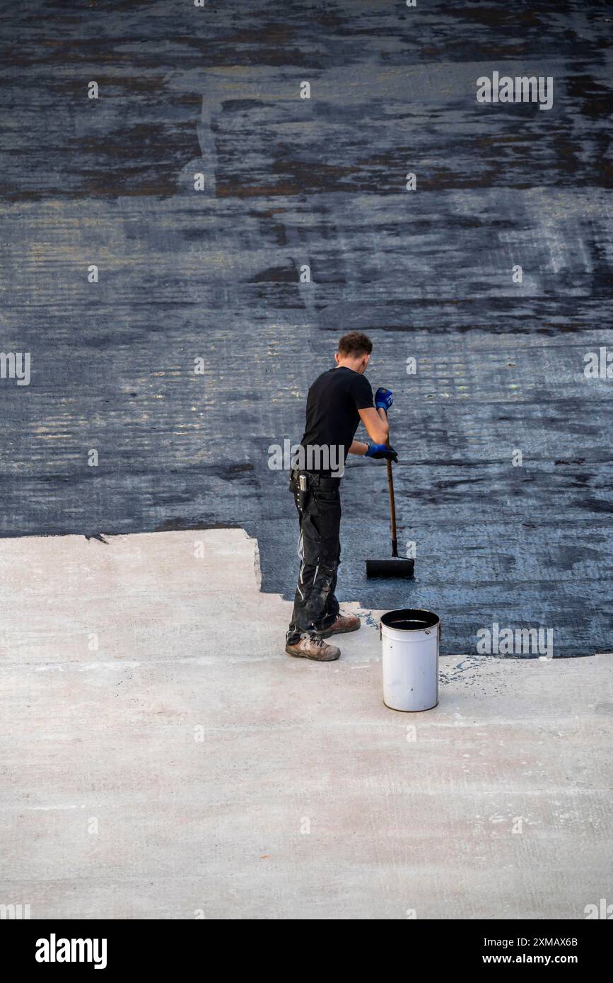 Chantier de construction, application d'un revêtement de bitume sur un plafond en béton, préparation pour l'imperméabilisation, avec membranes de bitume appliquées thermiquement Banque D'Images