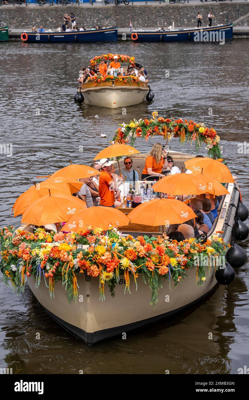 Croisière sur le canal, avec organisateur phare, bateaux de canal décorés de fleurs, passagers avec parasols contre le soleil d'été, chaleur, jetée à Centraal Banque D'Images