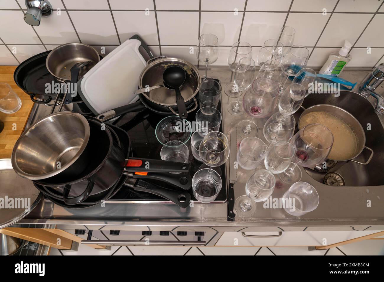 Cuisine après un grand dîner, partie de cuisine, vaisselle, verres sales, ustensiles de cuisine sur l'évier, en attente d'être lavé Banque D'Images