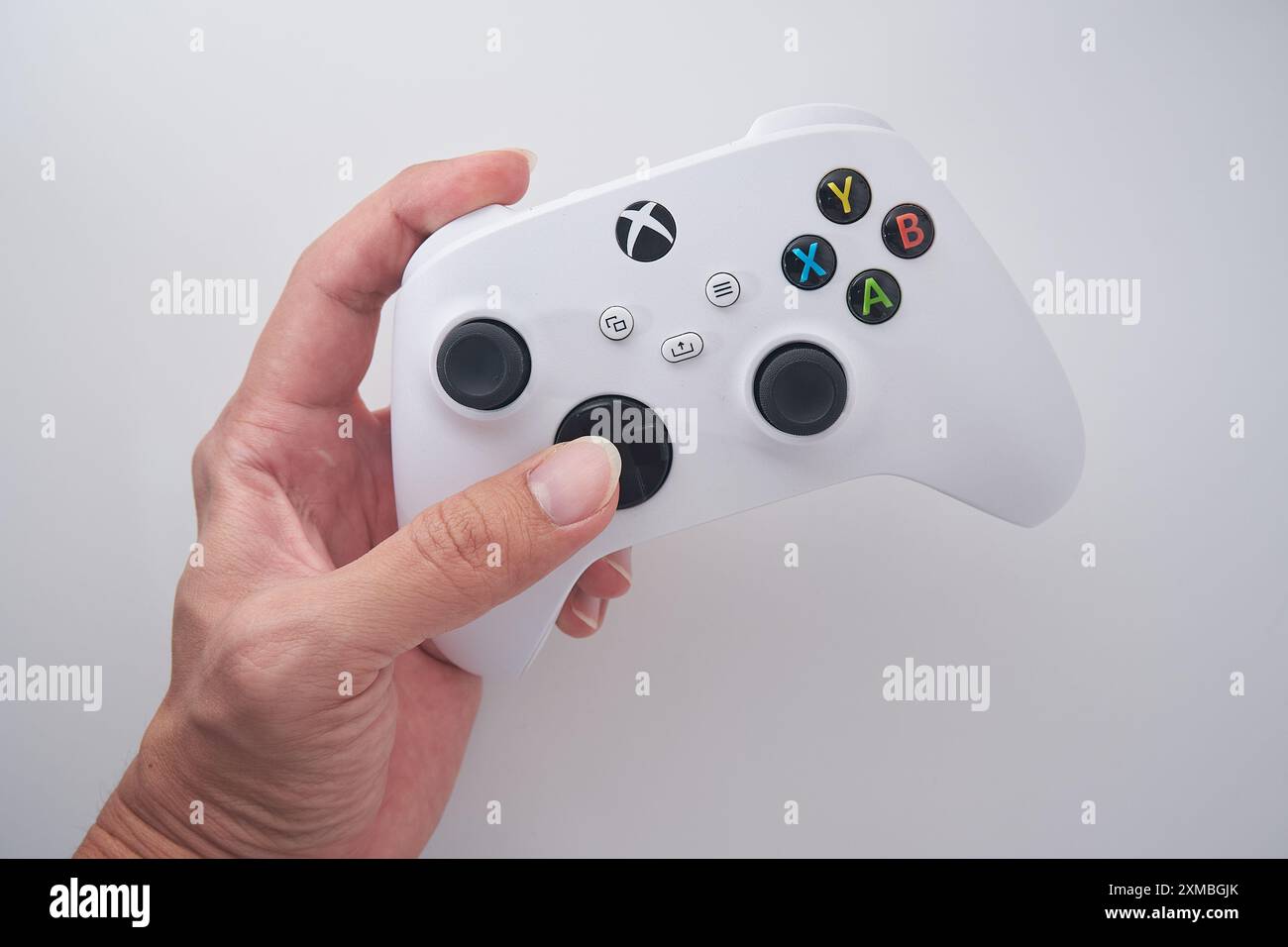 Un homme tient une manette XBOX avec un fond blanc. Banque D'Images