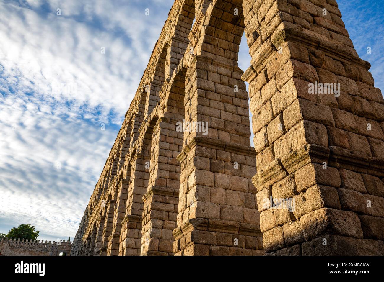 Vue d'en bas d'un détail de l'impressionnant aqueduc de Ségovie, Espagne, avec de grands blocs de pierre illuminés au crépuscule Banque D'Images
