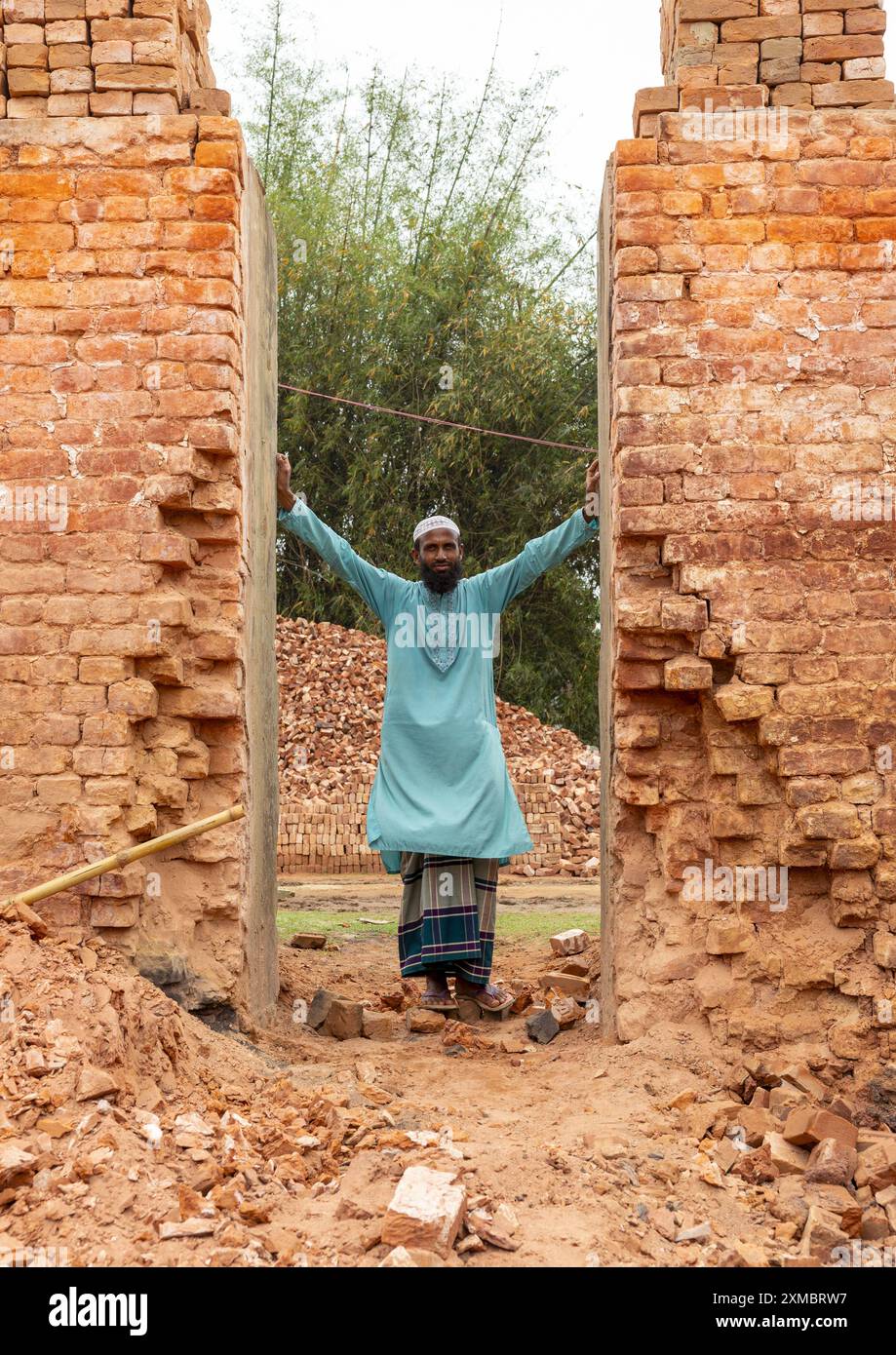 Se tenant debout dans l'entrée d'un four de son usine de briques, Sylhet Division, Bahubal, Bangladesh Banque D'Images