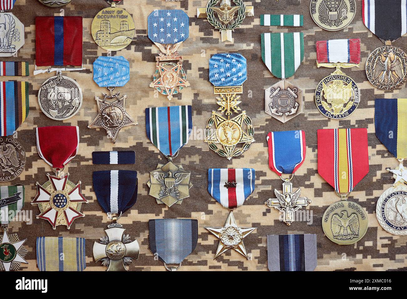 KIEV, UKRAINE - 10 JUILLET 2024 de nombreuses médailles militaires américaines sur fond de camouflage. Les États-Unis décernent des médailles. Accessoires de théâtre en papier faits à la main en gros plan Banque D'Images