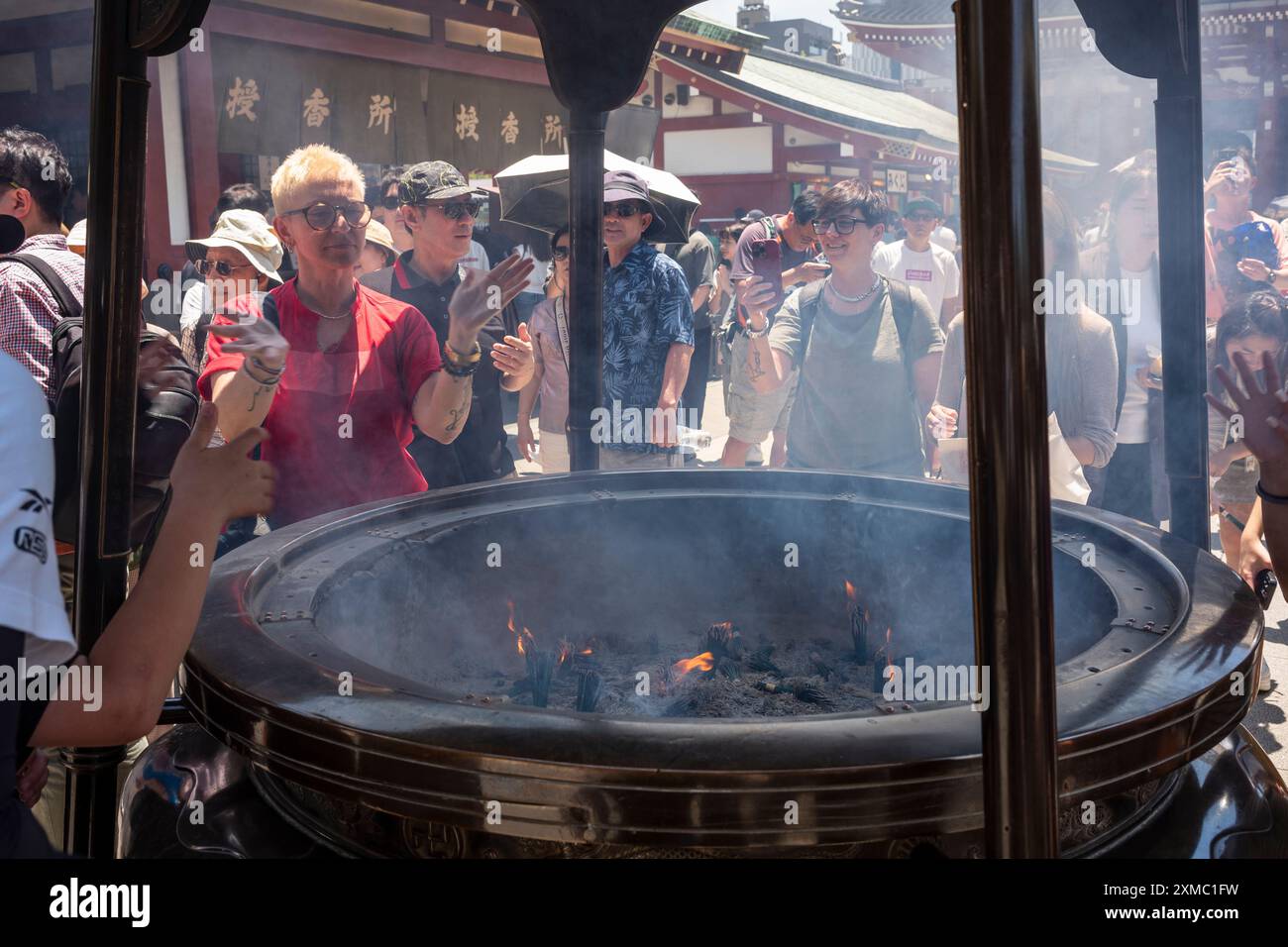 Tokyo, Japon - 15 juin 2024 : de nombreux touristes visitent le temple Senso-Ji, le plus ancien temple de Tokyo, pendant une journée d'été. La fumée sacrée de sens Banque D'Images