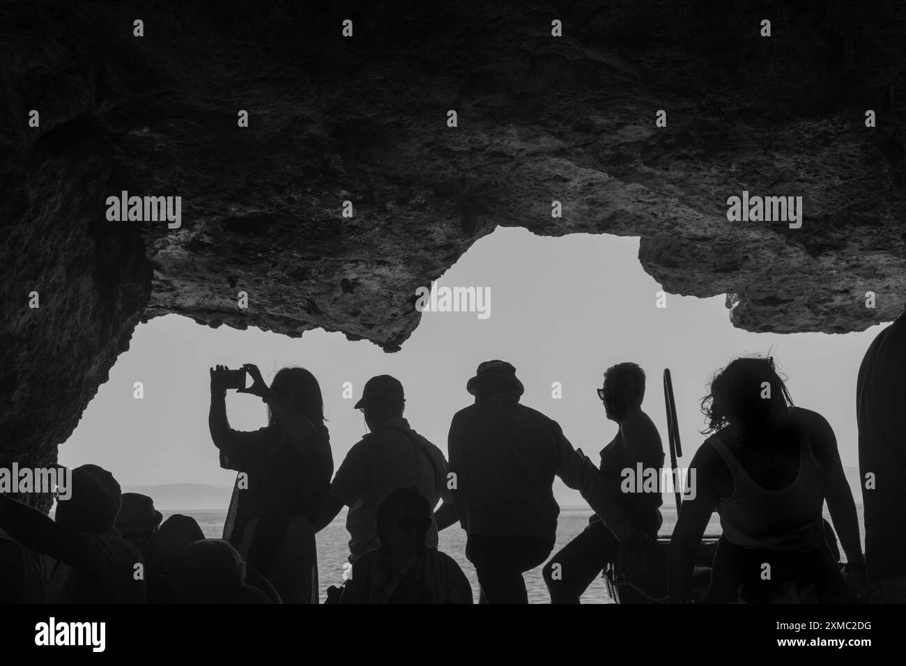 Silhouettes de personnes sur un bateau dans une grotte dans la mer Adriatique, îles Tremiti, Italie Banque D'Images