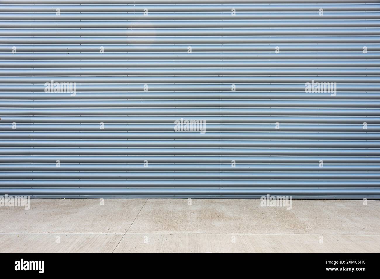 surface de façade de bâtiment d'usine en métal ondulé gris avec plancher de béton. Banque D'Images