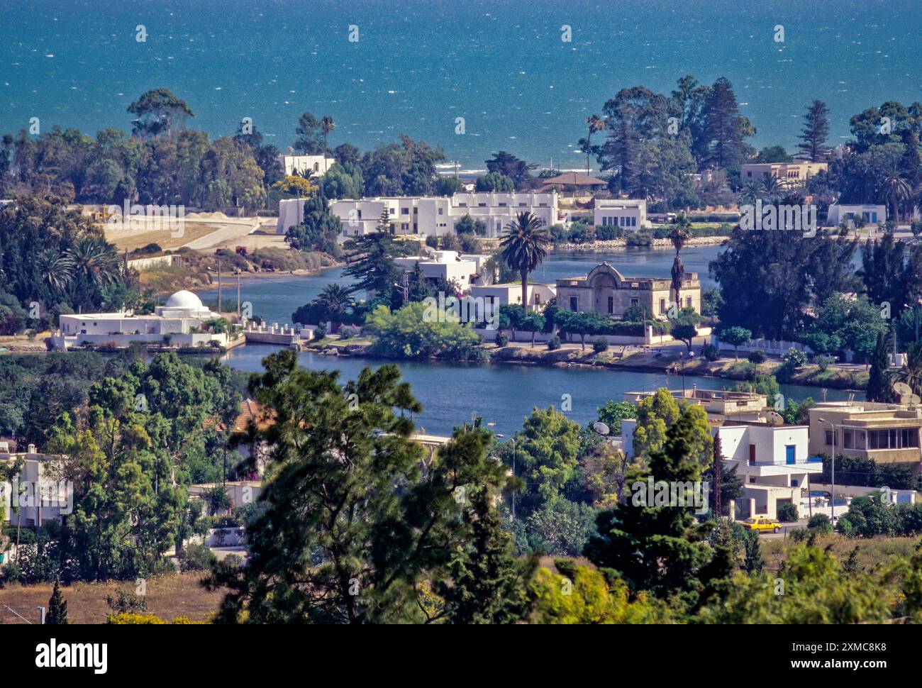 Carthage, Tunisie. Ports puniques, maintenant ressemblant à de petits lacs bordés de maisons luxueuses, date à partir de la 4ème. Siècle avant J.-C. L'avant-plan est le naval, ou militaire, port. Le port commercial est adjacente, plus loin. Baie de Tunis dans l'arrière-plan. Banque D'Images