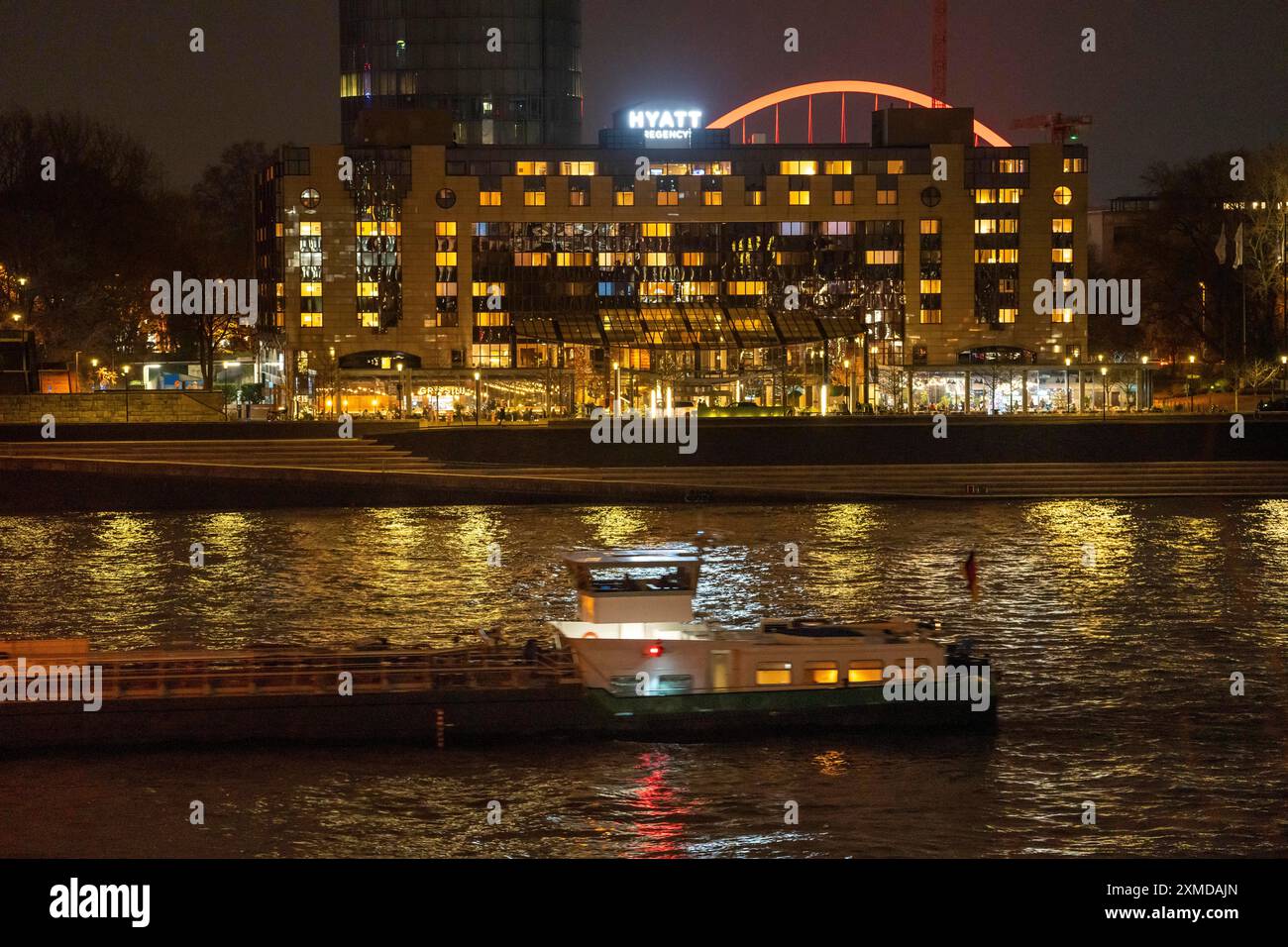 L'Hôtel Hyatt Regency sur le Rhin, à Cologne Deutz, derrière lui l'arc illuminé de la Lanxess Arena, navire cargo sur le Rhin, Nord Banque D'Images