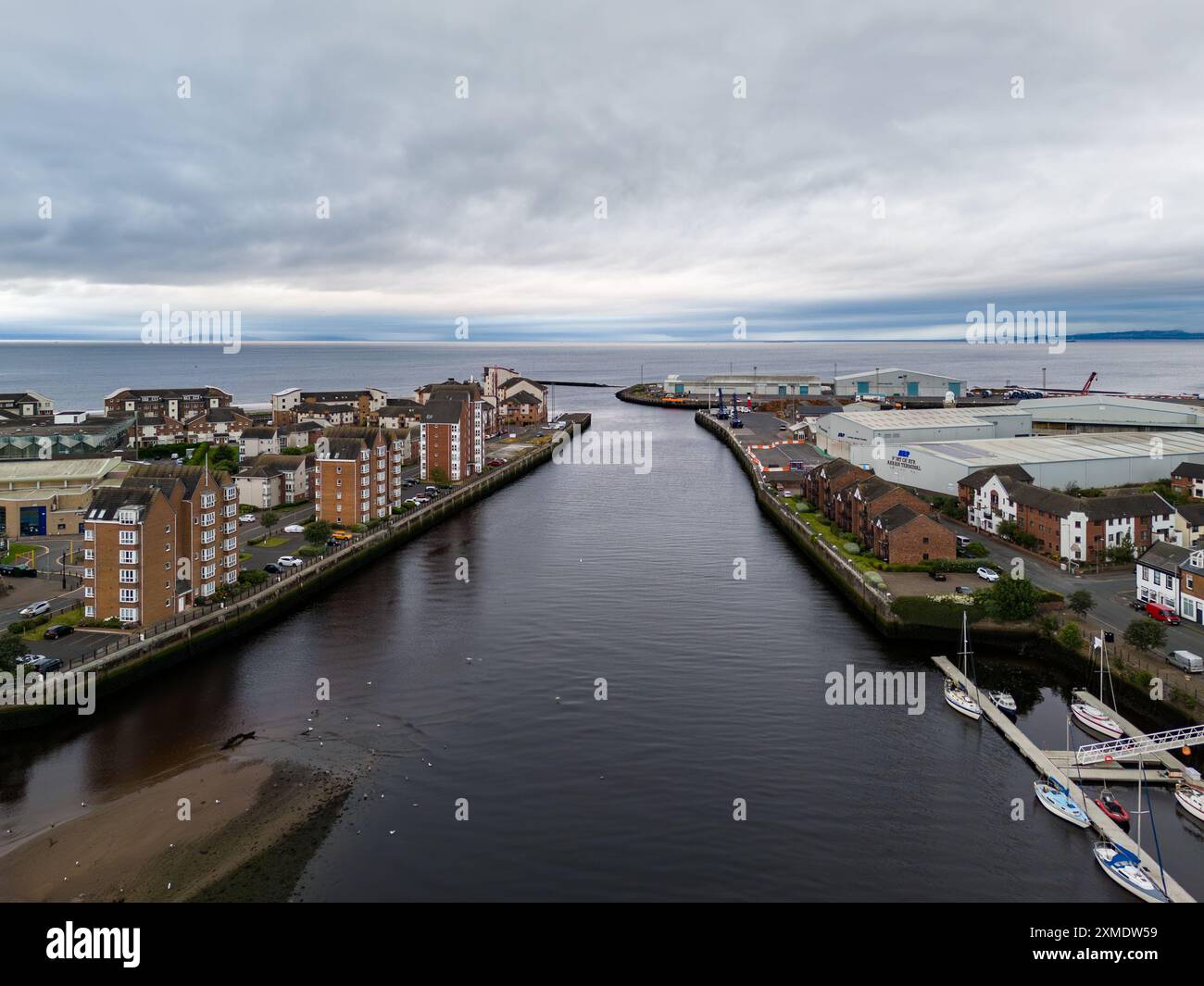 Vue aérienne de la rivière clyde qui coule vers la mer, séparant les bâtiments industriels des bâtiments résidentiels, par une journée nuageuse en écosse Banque D'Images