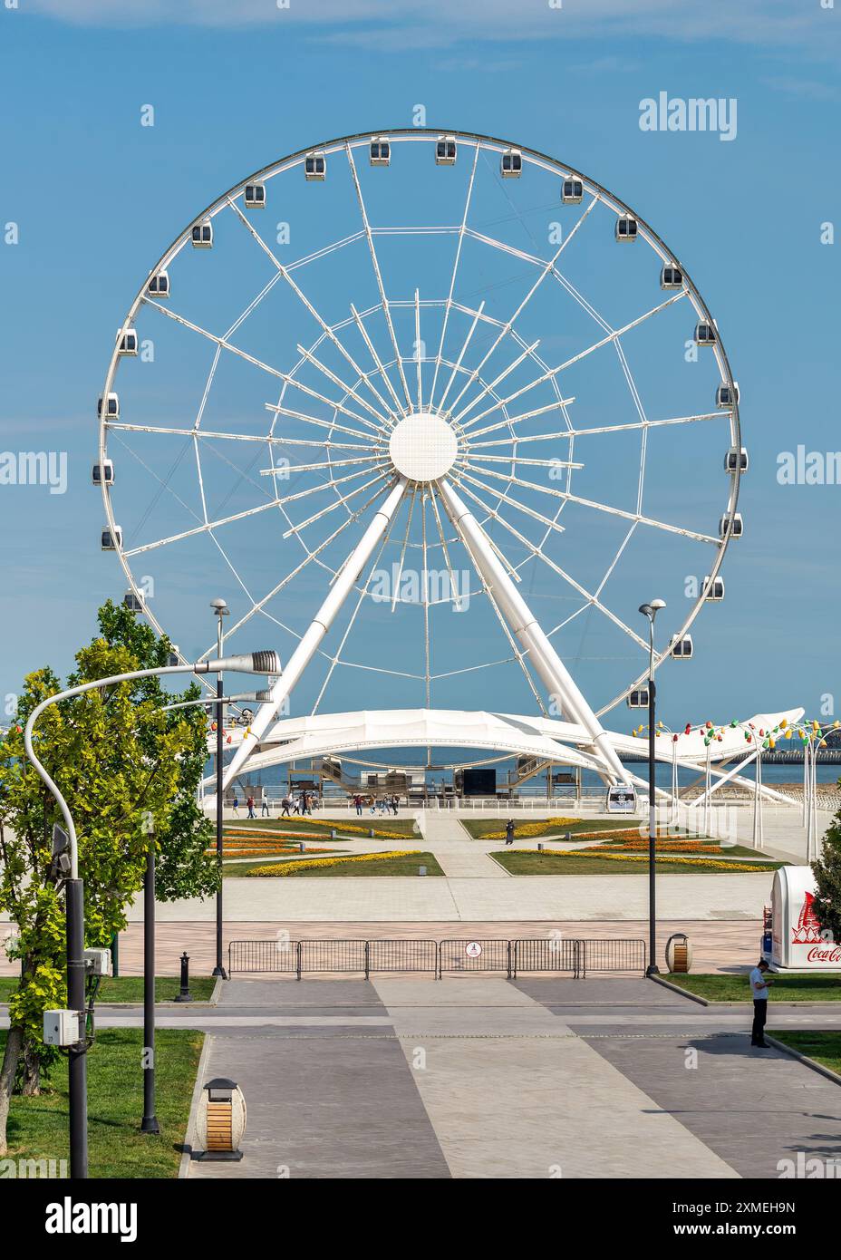Bakou, Azerbaïdjan - 4 mai 2024 : vue de la grande roue Baku Eye, située à côté du centre commercial Deniz. La roue est en arrière-plan avec peu de gens marchant au premier plan. Banque D'Images