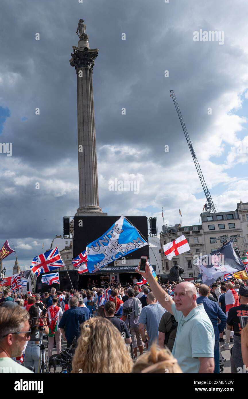 Londres, Royaume-Uni. 27 juillet 2024. La foule a vu agiter des drapeaux pendant le rallye. Les partisans de l’ex-dirigeant de l’EDL (Ligue de défense anglaise) et fondateur Tommy Robinson, de son vrai nom Stephen Christopher Yaxley-Lennon, ont défilé vers Trafalgar Square pour manifester contre ce qu’ils appellent un « système de police à deux vitesses », l’immigration et le mouvement LGBTQ. Une contre-manifestation a également été organisée par divers groupes. Crédit : SOPA images Limited/Alamy Live News Banque D'Images