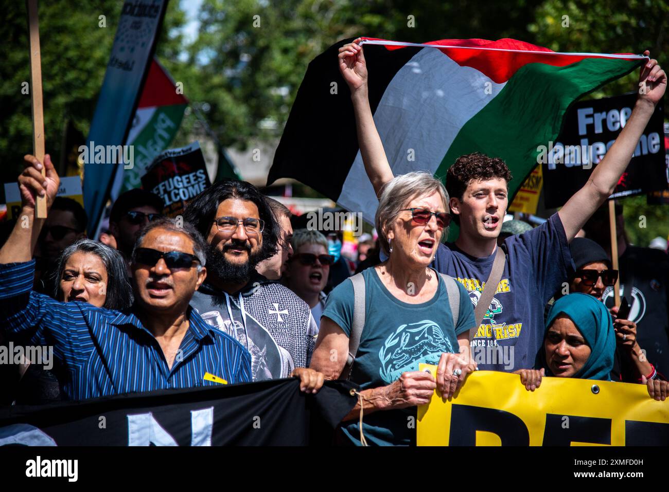 Les manifestants défilent avec une grande bannière et un drapeau palestinien pendant la manifestation. Tommy Robinson a convoqué une manifestation dans le centre de Londres. Robinson a une longue histoire de mobilisation des voyous racistes et fascistes d'extrême droite. La récente série de manifestations d'extrême droite a visé la population musulmane et les mobilisations palestiniennes. L'extrême droite a fait cause commune avec les organisations pro-israéliennes et a essayé de prétendre que les marches pacifiques de masse en Palestine sont des « marches de haine ». Cela fait partie de leur islamophobie implacable. Ils sont sortis et ont attaqué la police en réponse à Suella B. Banque D'Images Les manifestants défilent avec une grande bannière et un drapeau palestinien pendant la manifestation. Tommy Robinson a convoqué une manifestation dans le centre de Londres. Robinson a une longue histoire de mobilisation des voyous racistes et fascistes d'extrême droite. La récente série de manifestations d'extrême droite a visé la population musulmane et les mobilisations palestiniennes. L'extrême droite a fait cause commune avec les organisations pro-israéliennes et a essayé de prétendre que les marches pacifiques de masse en Palestine sont des « marches de haine ». Cela fait partie de leur islamophobie implacable. Ils sont sortis et ont attaqué la police en réponse à Suella B. Banque D'Images