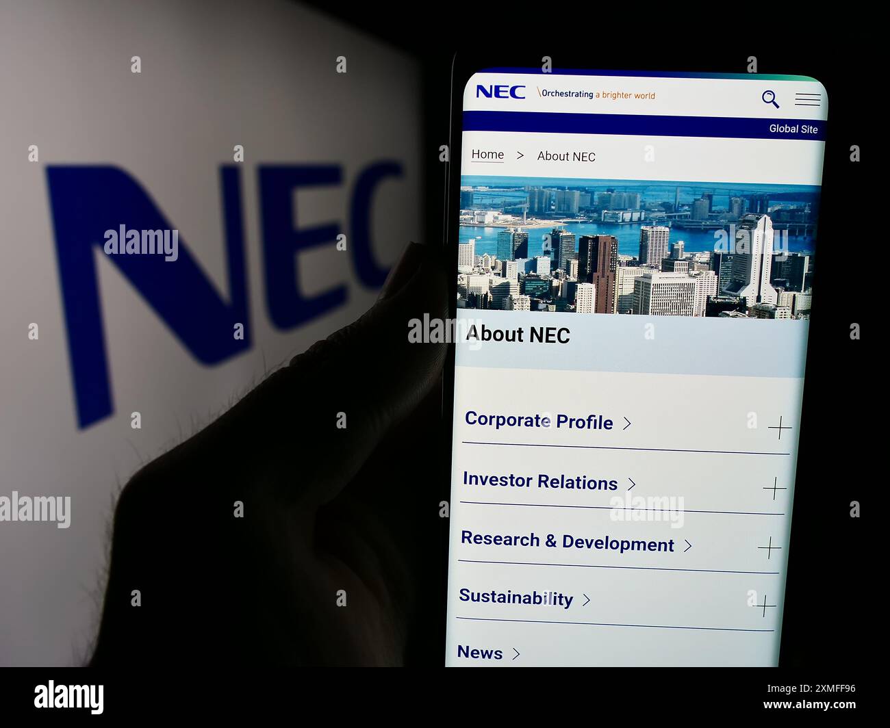 Personne tenant le téléphone portable avec la page Web de la société japonaise de technologie de l'information NEC Corporation avec logo. Concentrez-vous sur le centre de l'écran du téléphone. Banque D'Images