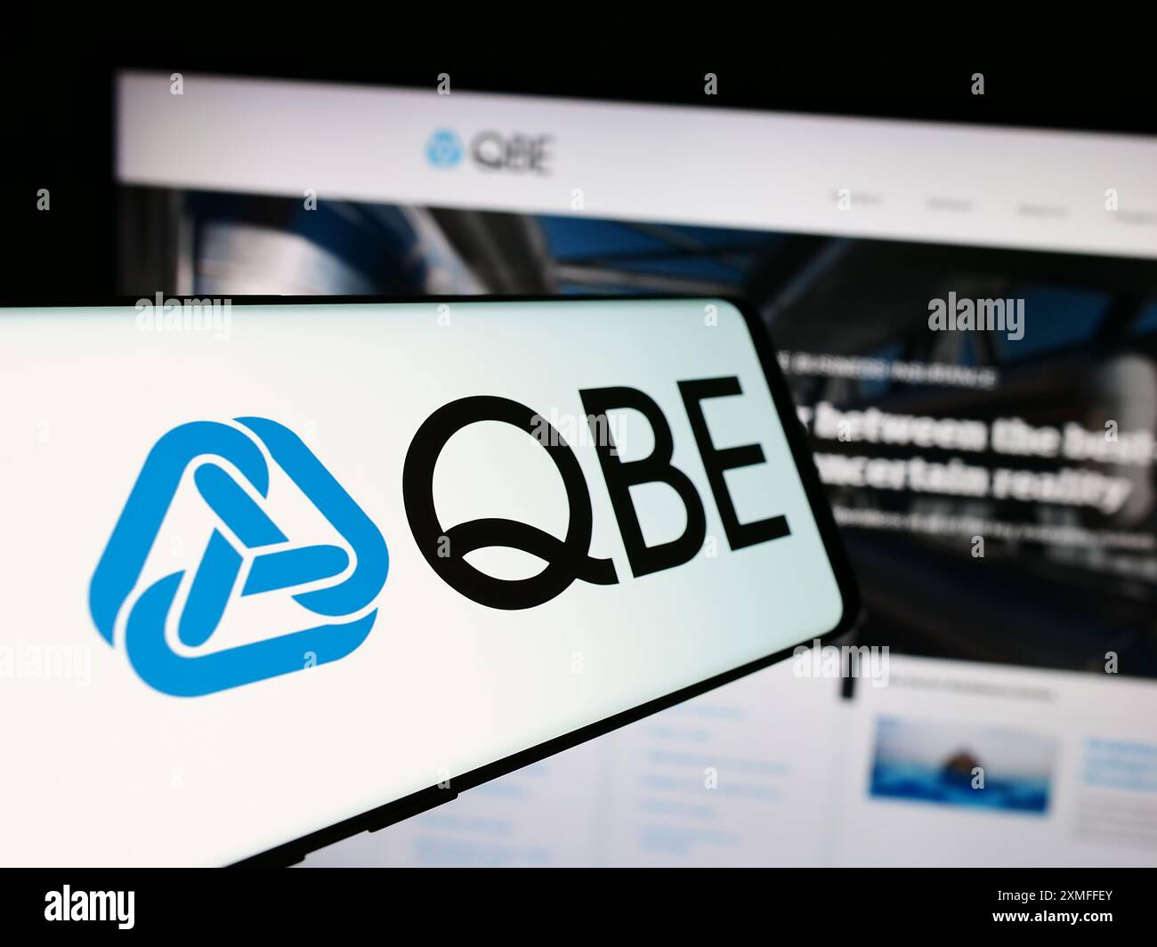 Smartphone avec logo de la société australienne QBE Insurance Group Limited devant le site Web de l'entreprise. Concentrez-vous sur le centre de l'écran du téléphone. Banque D'Images