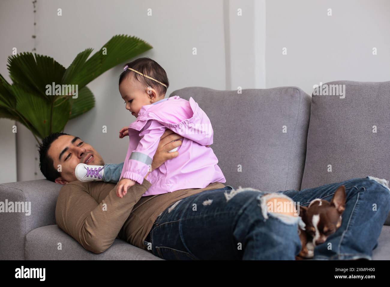Papa et petite fille allongés sur le canapé à la maison Banque D'Images