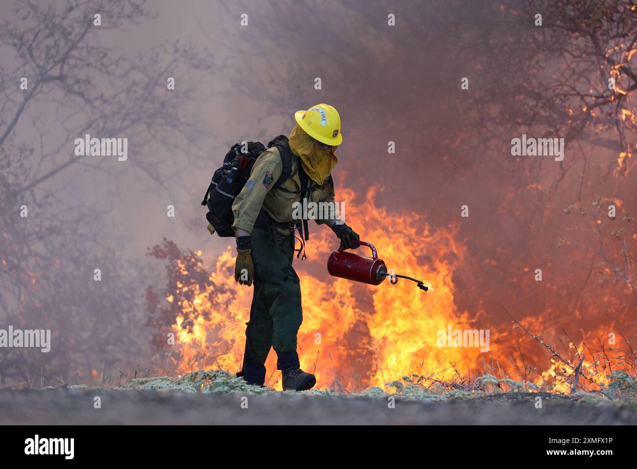 La photo montre des pompiers qui luttent contre les flammes le 25 juillet 2024 en Californie, aux États-Unis. Le plus grand incendie actif de Californie a explosé vendredi soir, augmentant rapidement au milieu d'un carburant sec et menaçant des milliers de maisons alors que les pompiers se précipitaient pour répondre au danger. L'intensité et la propagation rapide de l'incendie de Park ont conduit les responsables des incendies à faire des comparaisons indésirables avec le monstrueux incendie de Camp, qui a brûlé hors de contrôle dans Paradise voisin en 2018, tuant 85 personnes et incendiant 11 000 maisons. Plus de 130 structures ont été détruites par cet incendie jusqu'à présent, et des milliers d'autres restent Three Banque D'Images