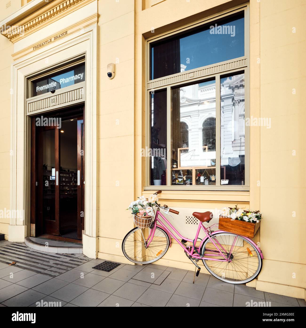 Fremantle Pharmacy sur High Street dans le quartier historique du West End avec un vélo rose pour dames avec panier et fleurs, Fremantle, Australie occidentale. Banque D'Images