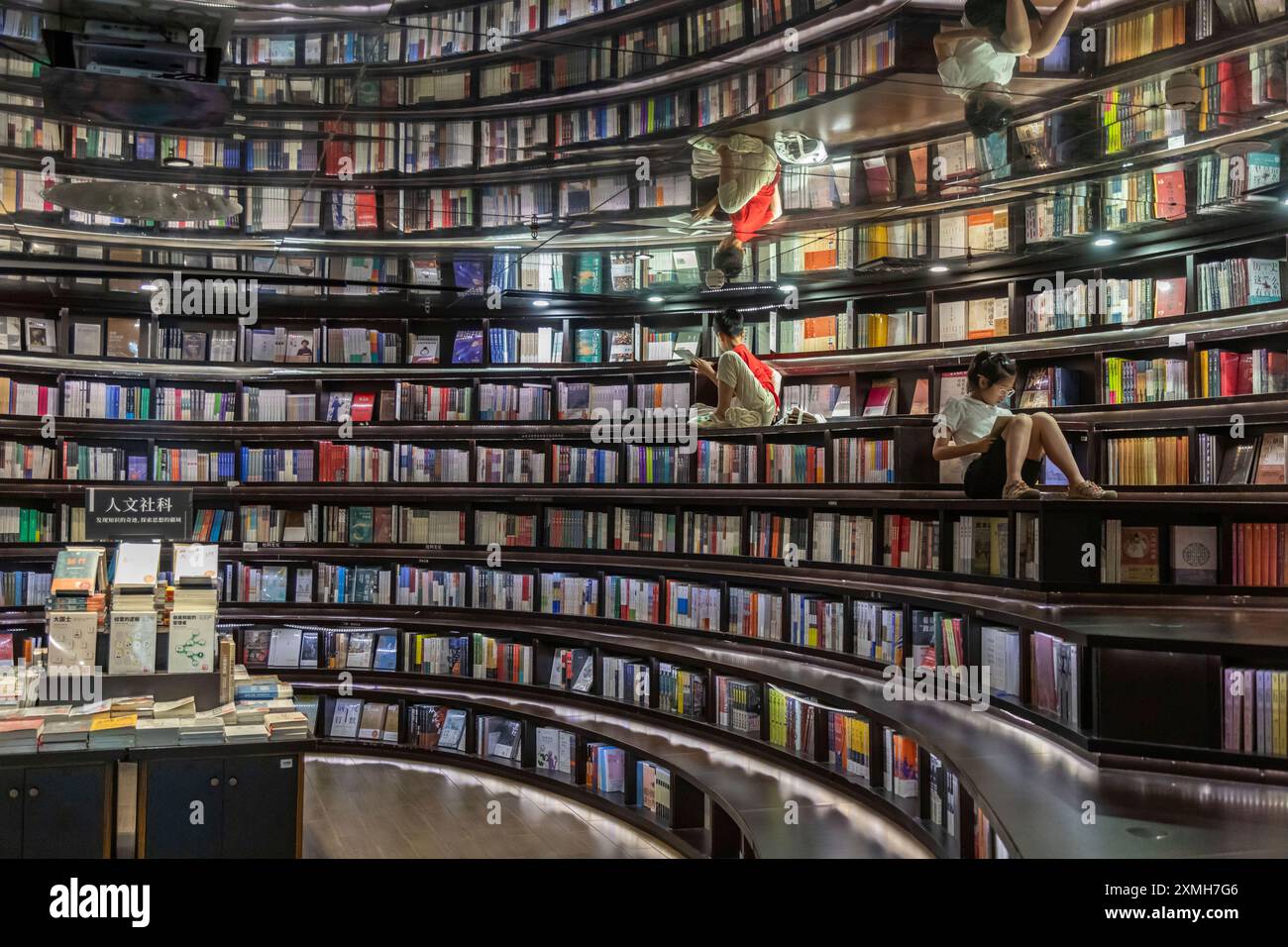 People read inside an outlet of Zhongshuge, a Chinese bookstore chain known for its fancy interior design, in Hangzhou in east China's Zhejiang province Sunday, July 28, 2024. (FeatureChina via AP Images) Banque D'Images