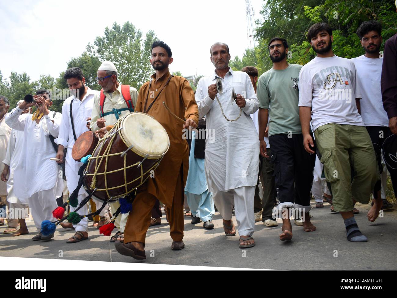 Srinagar, Cachemire, Inde, le 28 juillet 2024 : un groupe d'individus, marchant pieds nus et jouant de tambours et de flûtes, se rend au sanctuaire Sheikh-ul-Alam au Cachemire. Ils cherchent la pluie pour atténuer la vague de chaleur en cours dans la région. Chaque fois que le Cachemire connaît une catastrophe, les groupes se rendent au sanctuaire de Chari Sharief, situé à 28 kilomètres de Srinagar, où le cheikh Noor DIN (R.. A) le sanctuaire est situé. Ces groupes font le voyage à pied, pieds nus, interprétant le traditionnel Band Pather et priant pour ceux qui sont touchés par la catastrophe pendant qu'ils marchent. Photo danoise Showkat/Sipa USA. Banque D'Images