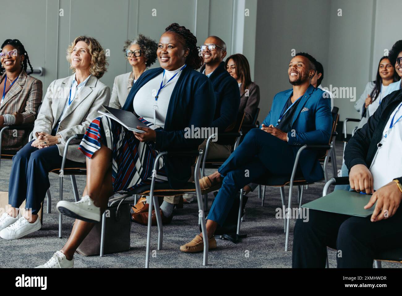 Public professionnel diversifié assis attentivement tout en écoutant une présentation lors d'un séminaire lors d'une conférence. Banque D'Images